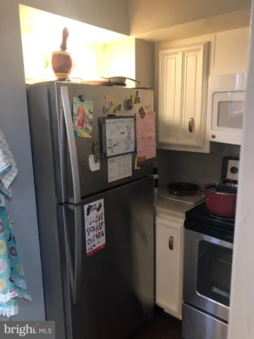 a kitchen with stainless steel appliances granite countertop a refrigerator a stove and a sink