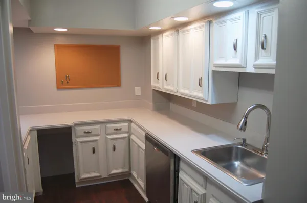 a kitchen with stainless steel appliances granite countertop a sink and cabinets with wooden floor