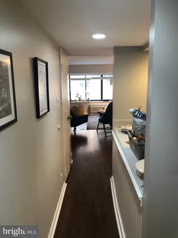a view of a hallway with furniture and floor to ceiling window