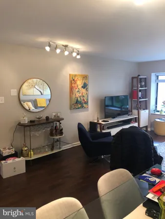 a living room with furniture a mirror and a lamp