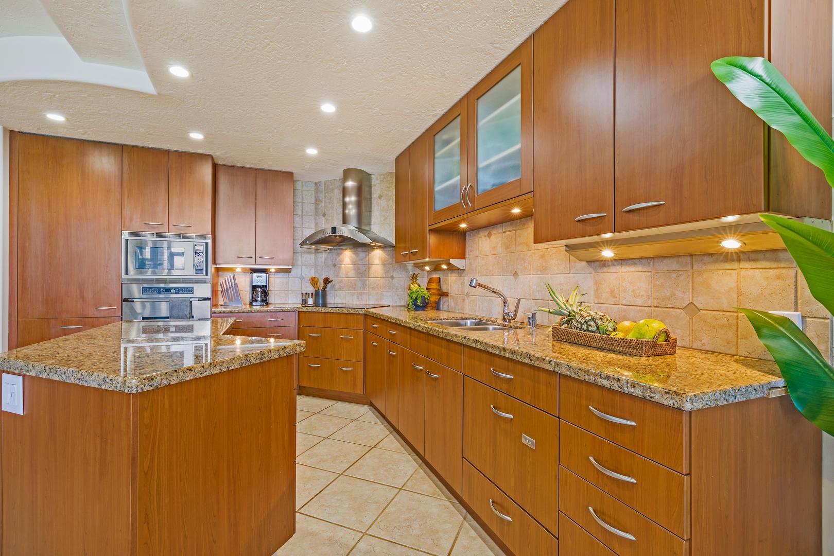 3875 Lower Honoapiilani Road, Unit B305 Lahaina, HI 96761 - Photo 15 of 35 a kitchen with kitchen island granite countertop wooden cabinets and a sink