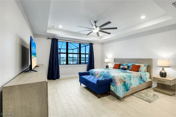 a spacious bedroom with a bed a chandelier and a large window