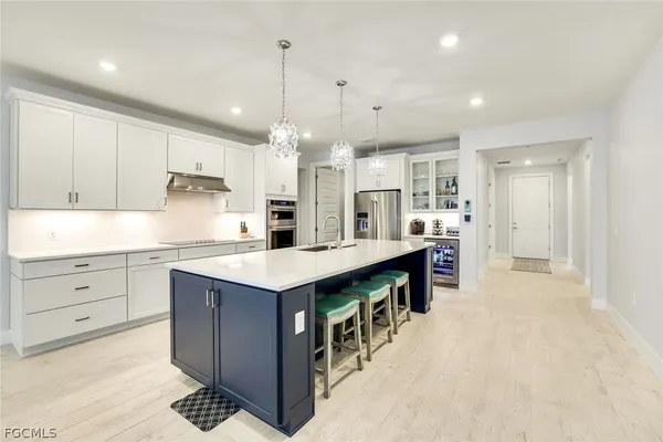 a kitchen with kitchen island a sink stove and refrigerator
