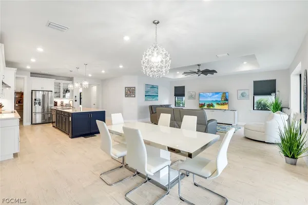 a kitchen with stainless steel appliances kitchen island granite countertop a refrigerator and a dining table