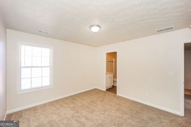 an empty room with windows and closet