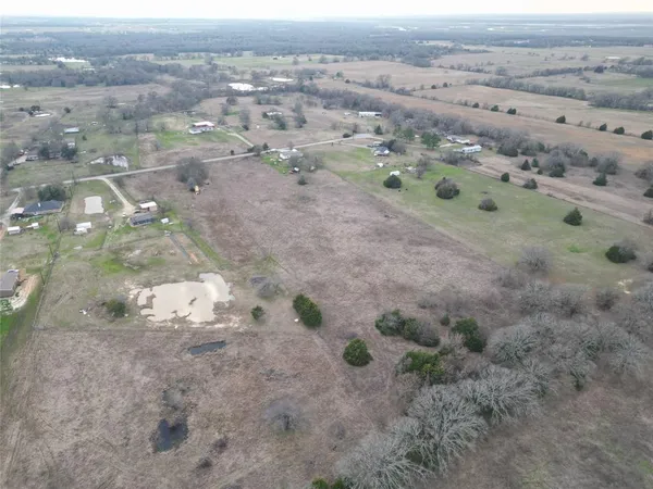 a view of a dry yard with trees