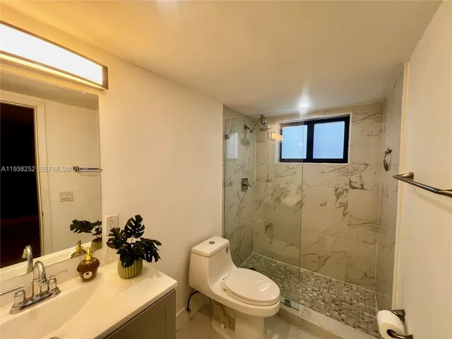 a bathroom with a sink mirror toilet and shower