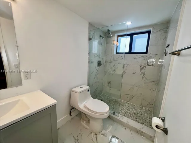 a white toilet sitting next to a bathroom sink