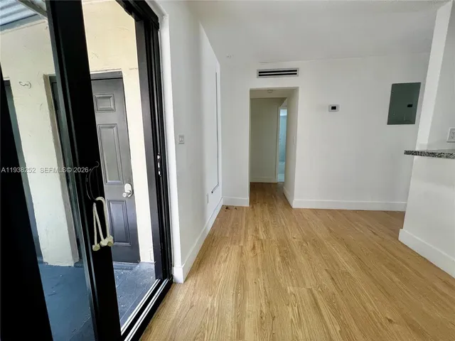a view of a hallway with wooden floor