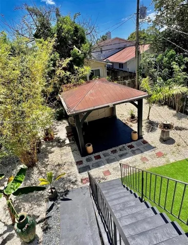 a view of a patio with table and chairs under an umbrella with a yard