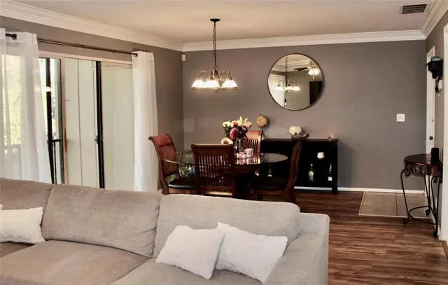 a living room with furniture chandelier and a mirror
