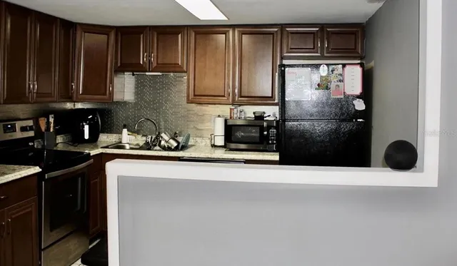 a kitchen with a refrigerator and a stove