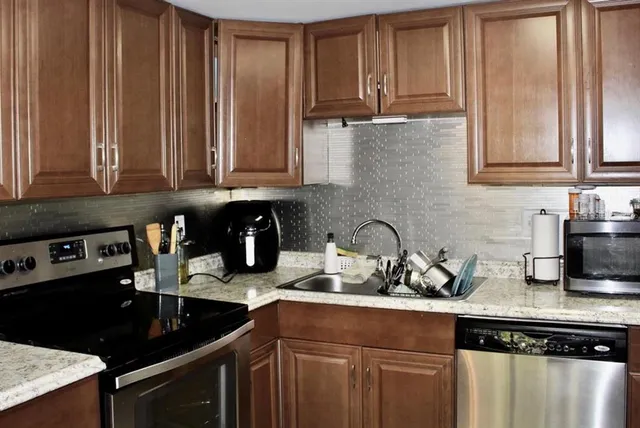 a kitchen with granite countertop a sink a stove and cabinets
