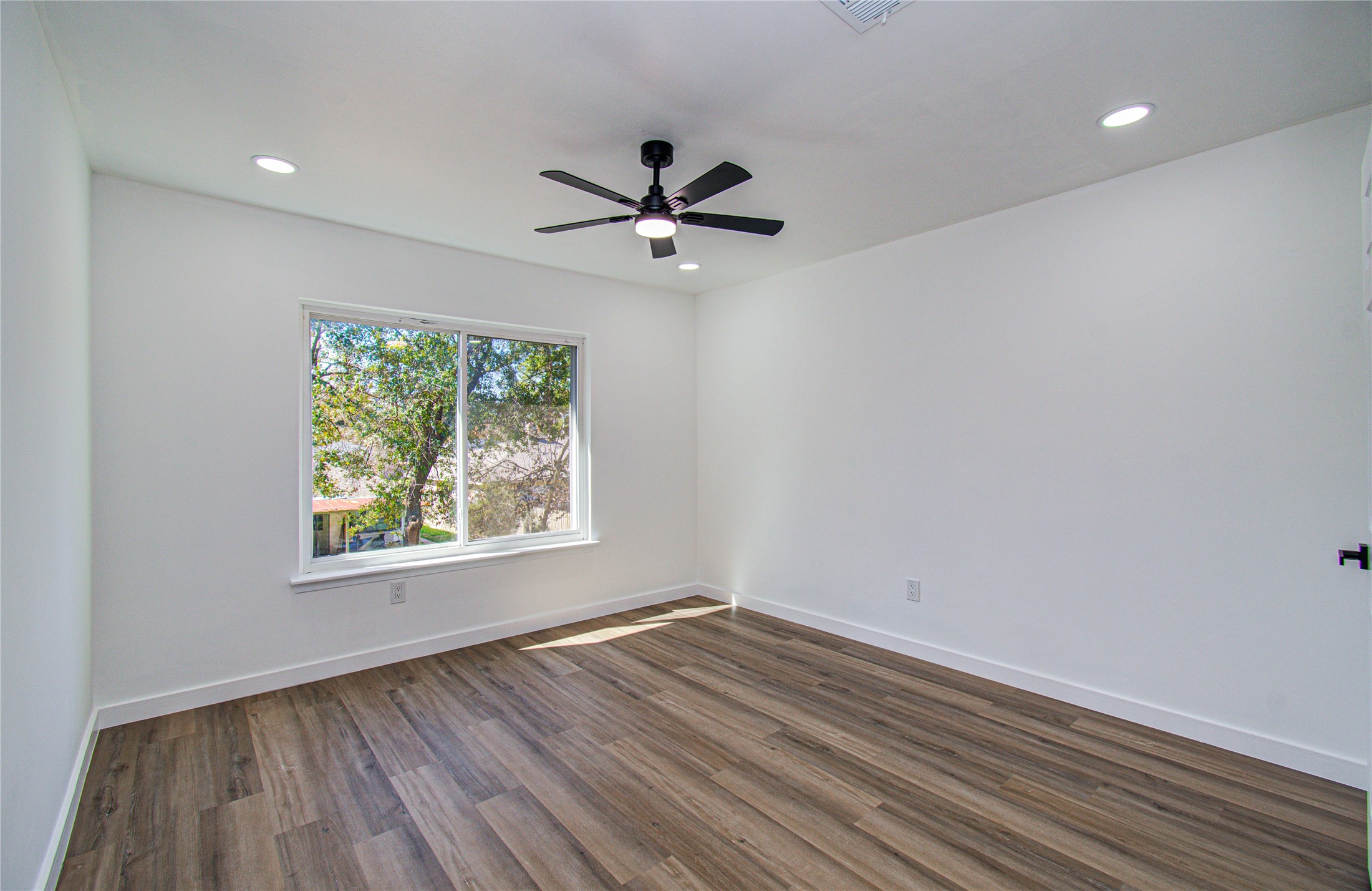 23319 Whispering Willow Drive Spring, TX 77373 - Photo 37 of 41 an empty room with wooden floor ceiling fan and windows
