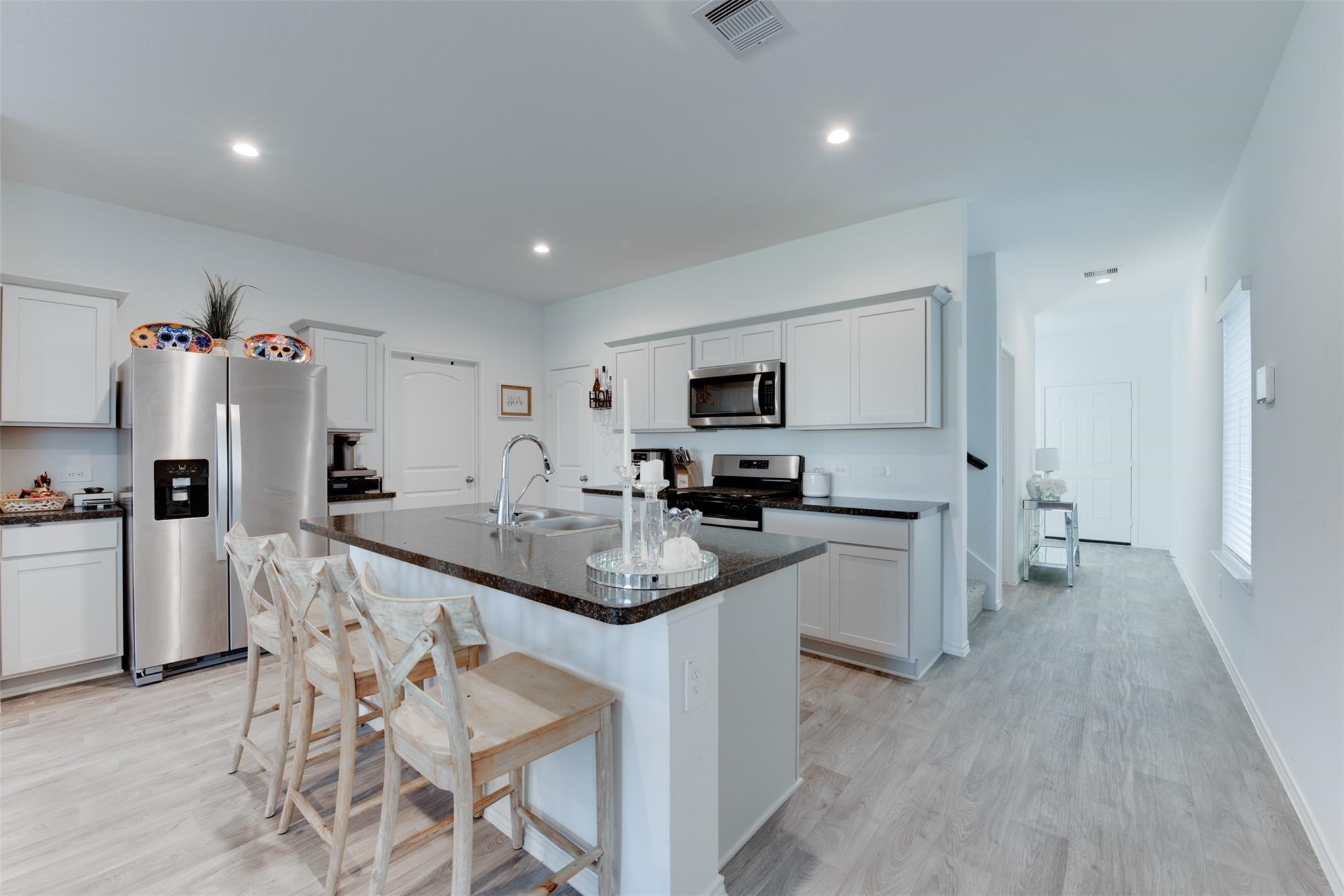 5339 Tuscany Hills Lane Spring, TX 77373 - Photo 7 of 28 a kitchen with white cabinets and stainless steel appliances