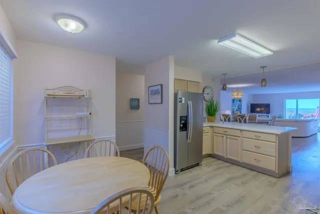 a kitchen with stainless steel appliances kitchen island granite countertop a refrigerator a stove a sink dishwasher with a dining table and chairs