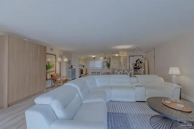 a living room with furniture and a dining table with wooden floor