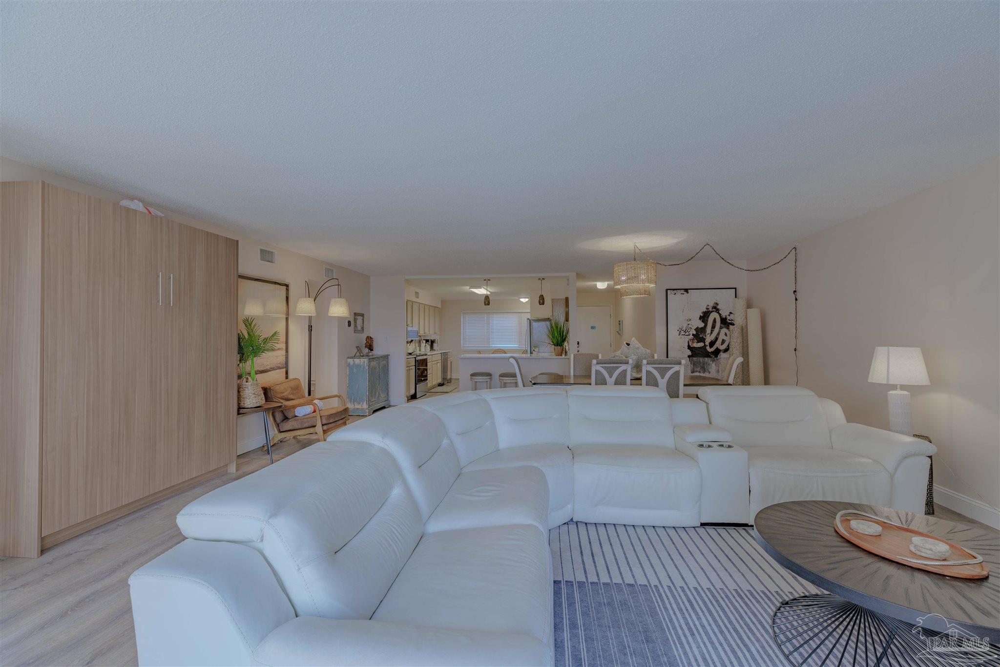 1111 Fort Pickens Road, Unit 312 Pensacola Beach, FL 32561 - Photo 12 of 40 a living room with furniture and a dining table with wooden floor