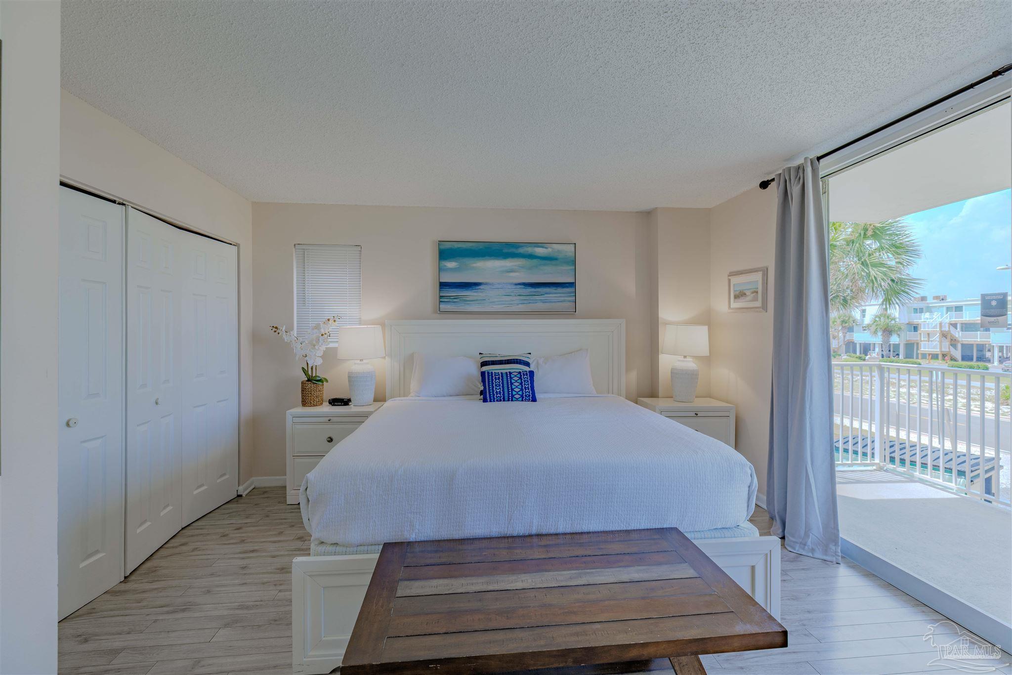1111 Fort Pickens Road, Unit 312 Pensacola Beach, FL 32561 - Photo 13 of 40 a bedroom with a bed and a large window