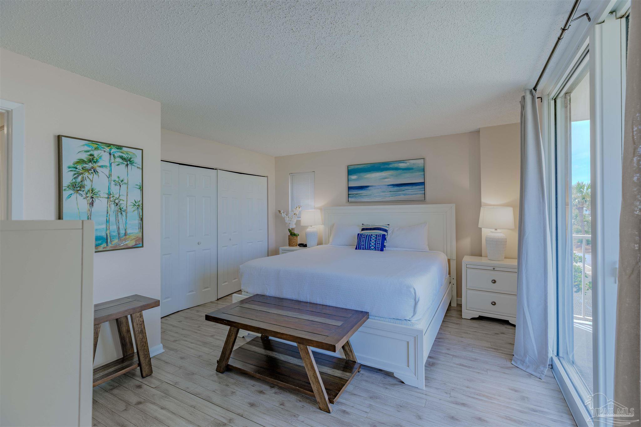 1111 Fort Pickens Road, Unit 312 Pensacola Beach, FL 32561 - Photo 14 of 40 a bedroom with a bed and a table in it