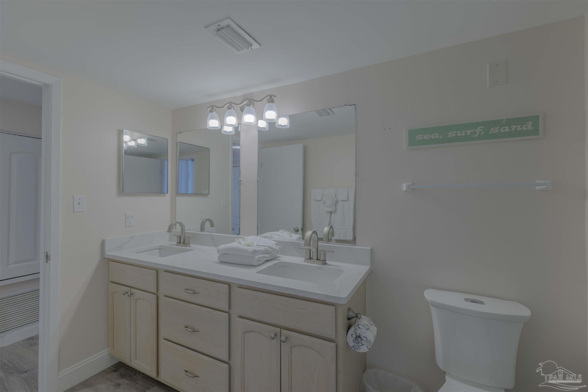 1111 Fort Pickens Road, Unit 312 Pensacola Beach, FL 32561 - Photo 15 of 40 a bathroom with a toilet sink and mirror