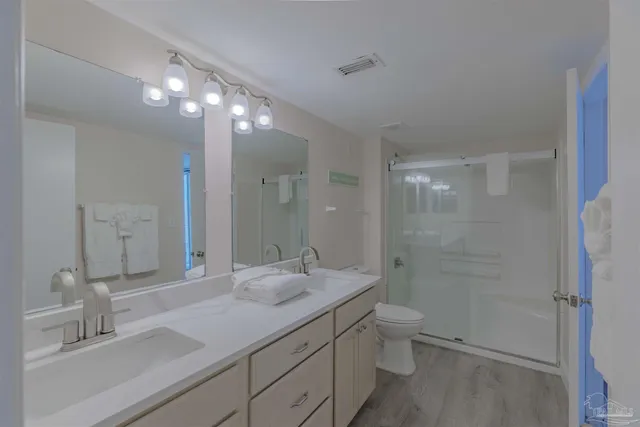 a bathroom with a sink a toilet a shower and a mirror