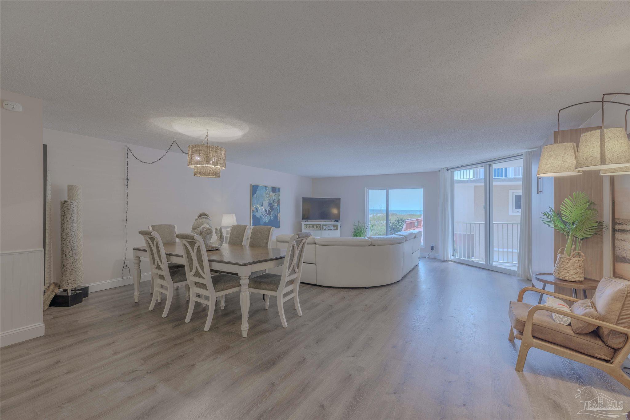 1111 Fort Pickens Road, Unit 312 Pensacola Beach, FL 32561 - Photo 4 of 40 a living room with furniture wooden floor and a chandelier