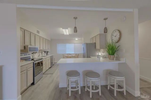 a kitchen with granite countertop stainless steel appliances a table and chairs in it