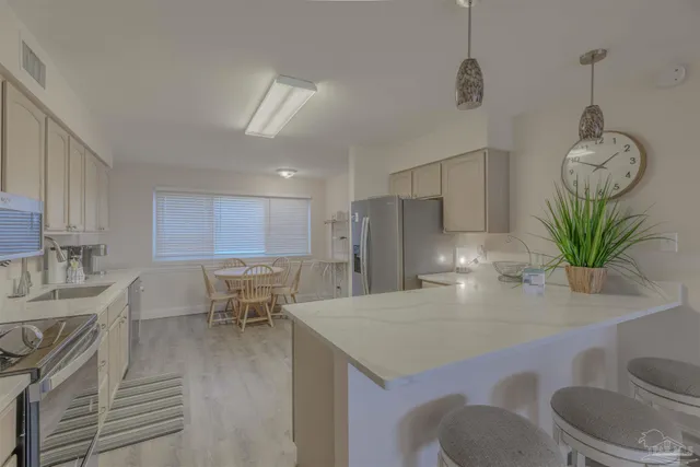 a view of kitchen with sink refrigerator dining table and chairs