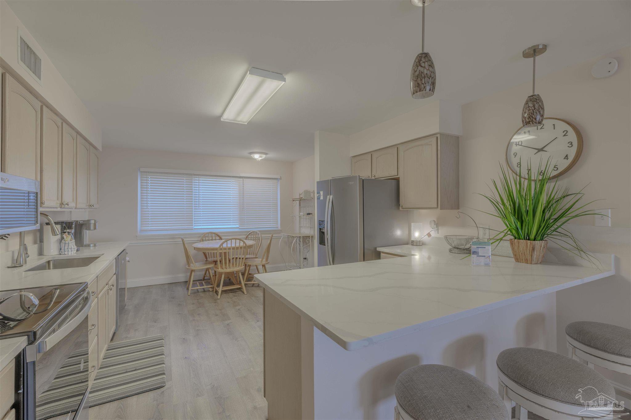 1111 Fort Pickens Road, Unit 312 Pensacola Beach, FL 32561 - Photo 10 of 40 a view of kitchen with sink refrigerator dining table and chairs