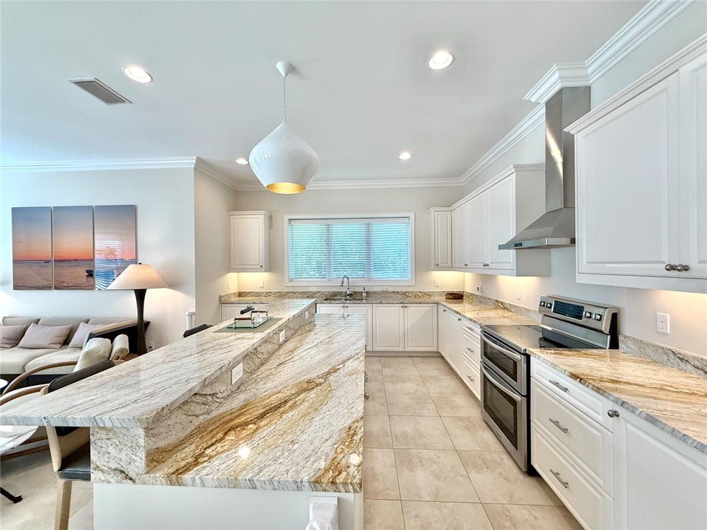 506 Cypress Road Vero Beach, FL 32963 - Photo 12 of 35 a large kitchen with stainless steel appliances kitchen island granite countertop a sink and cabinets