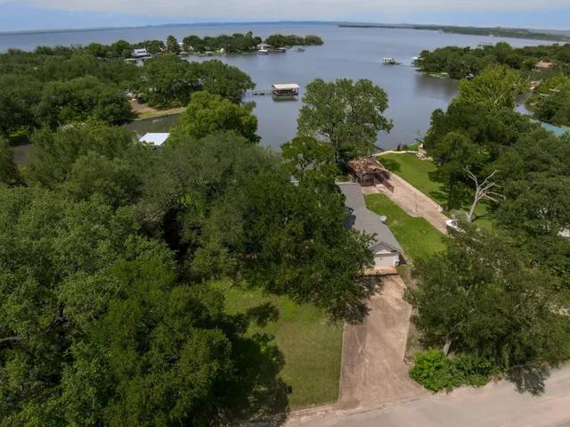 an aerial view of residential houses with outdoor space and lake view