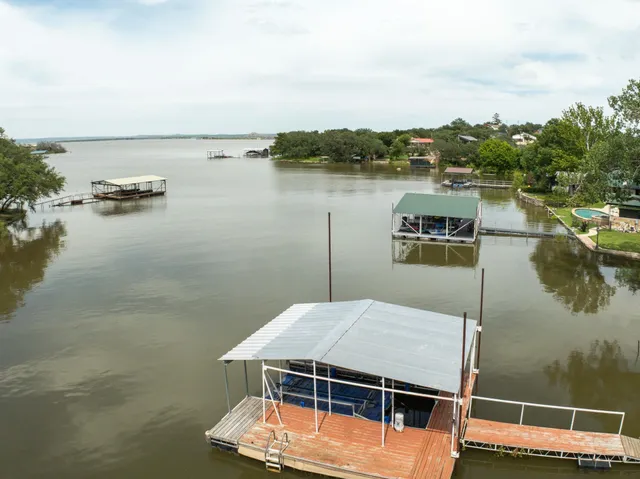 an aerial view of a house with swimming pool and lake view