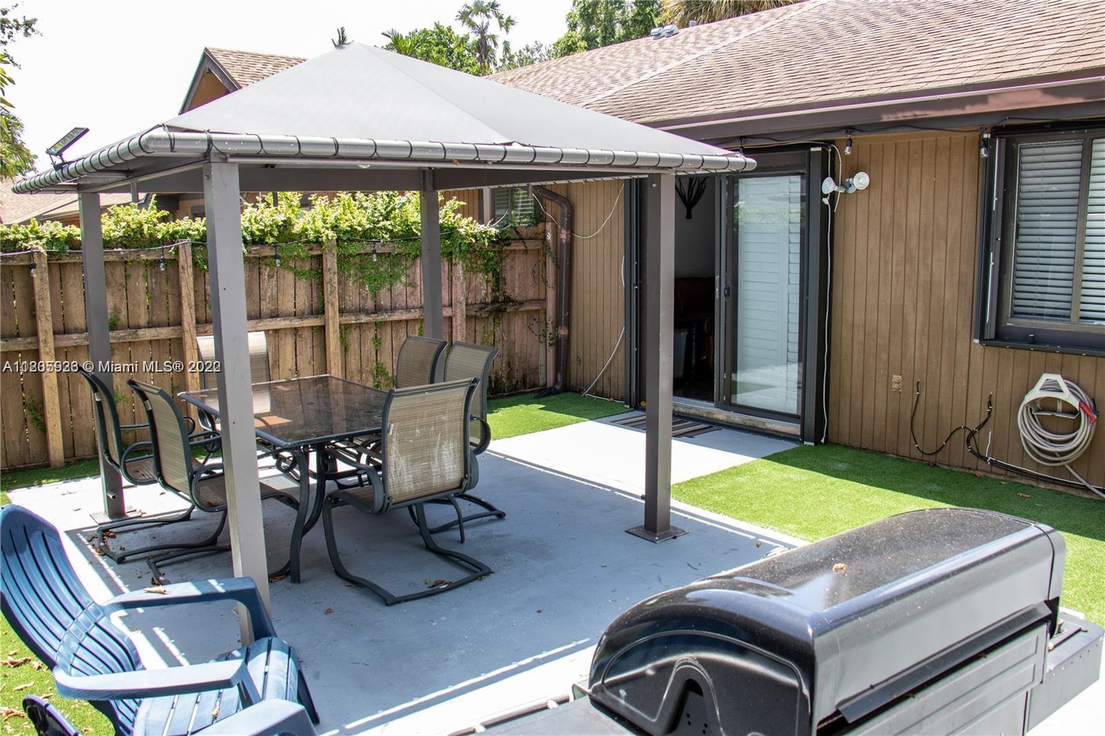 9300 Southwest 132nd Street, Unit 9300 Miami, FL 33176 - Photo 11 of 13 a view of a patio with a table chairs and a backyard