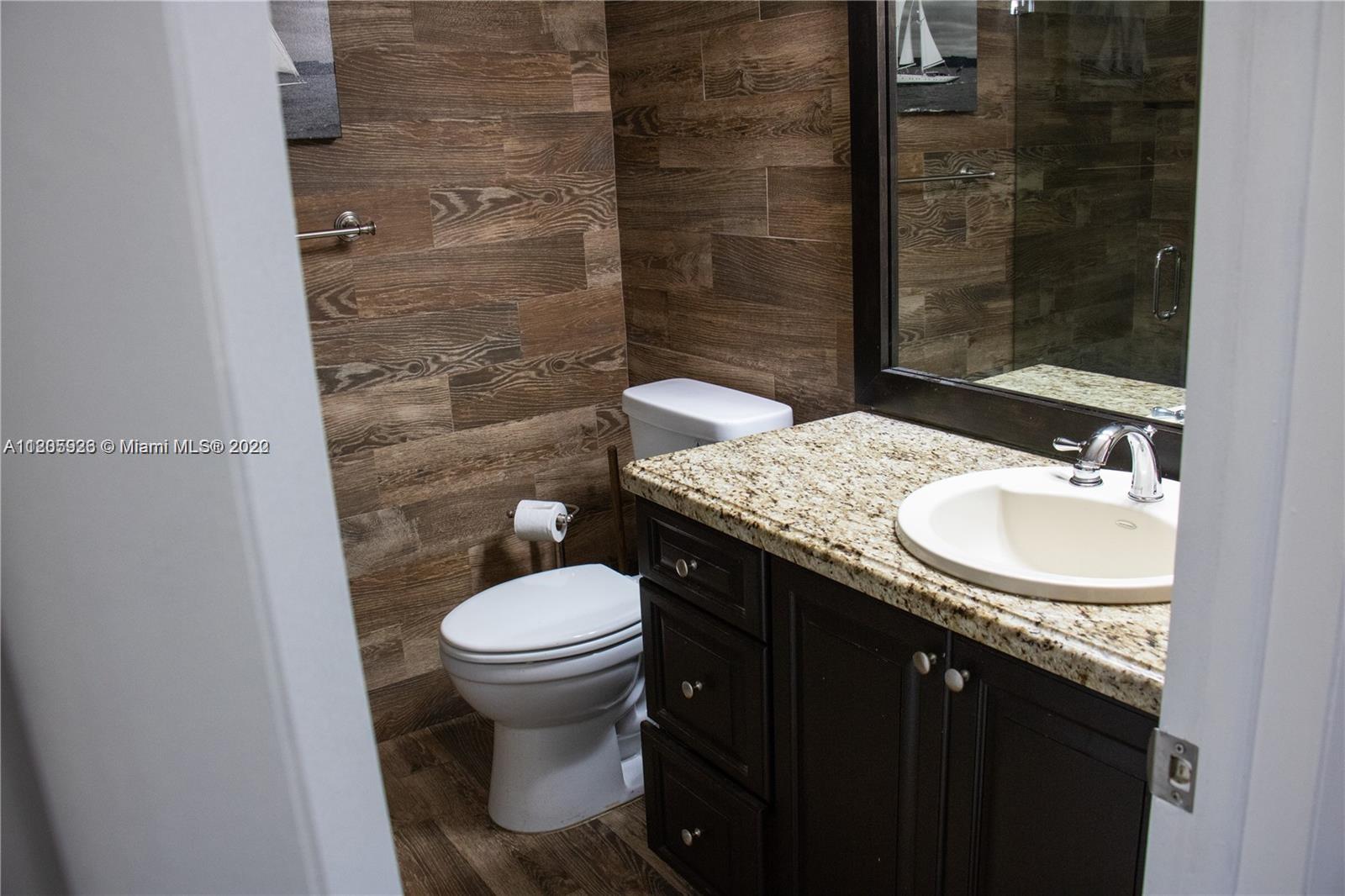 9300 Southwest 132nd Street, Unit 9300 Miami, FL 33176 - Photo 9 of 13 a bathroom with a granite countertop sink toilet and shower
