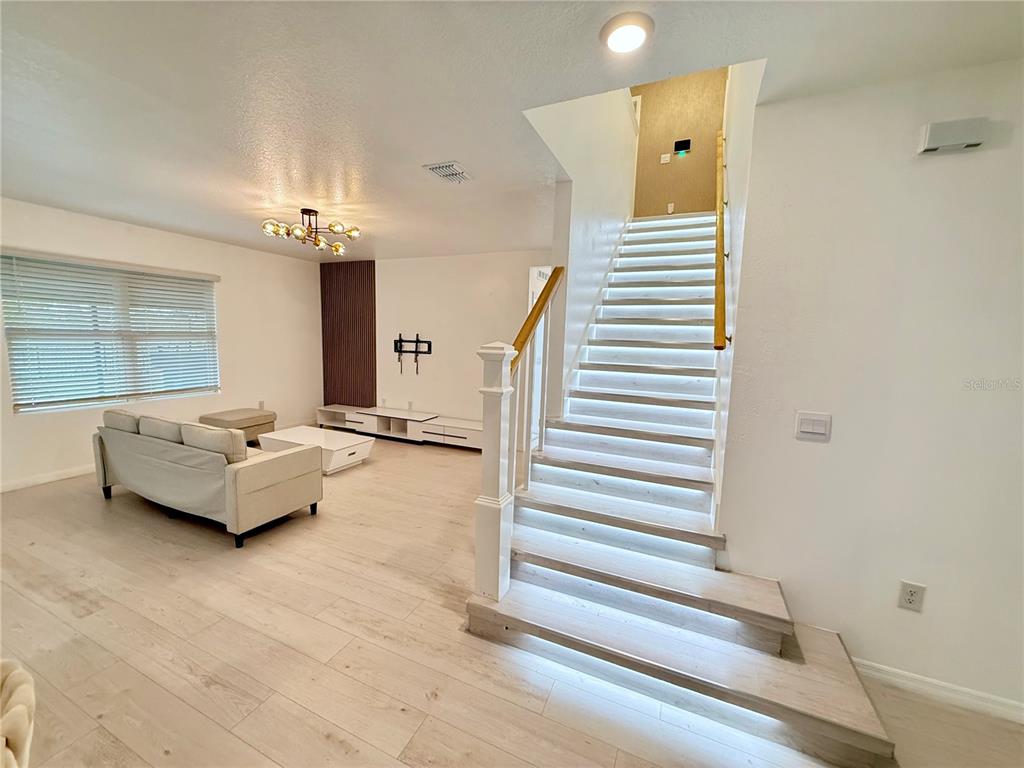 2731 House Finch Road Harmony, FL 34773 - Photo 14 of 95 a living room with furniture and a chandelier