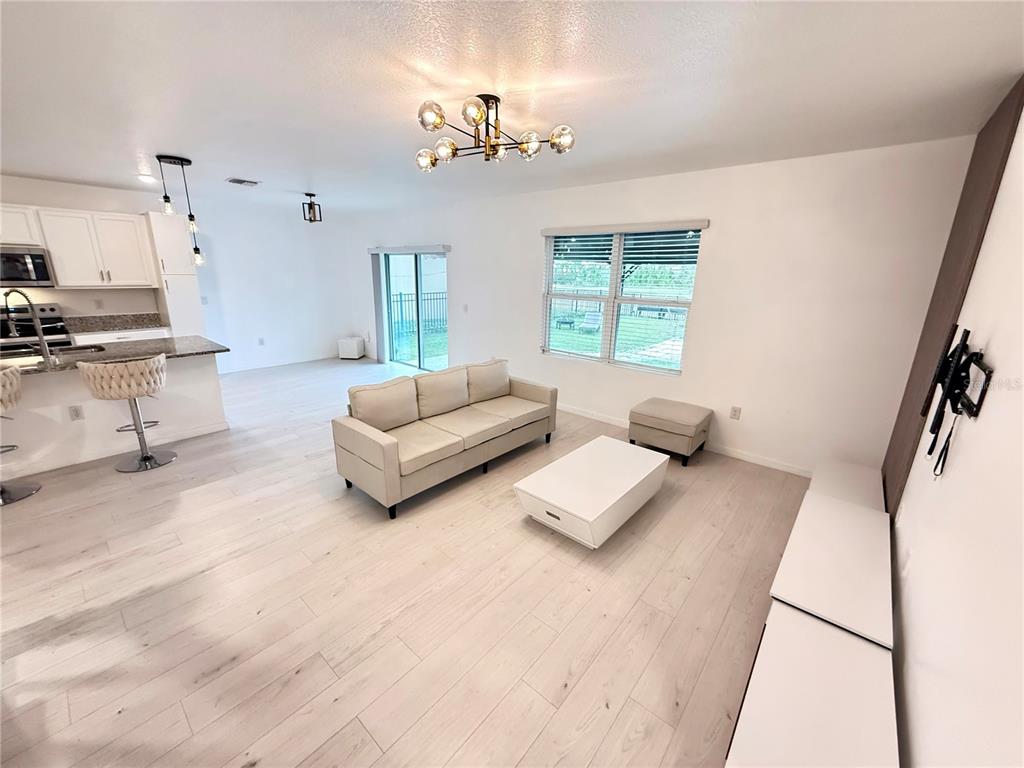 2731 House Finch Road Harmony, FL 34773 - Photo 18 of 95 a living room with furniture and a chandelier