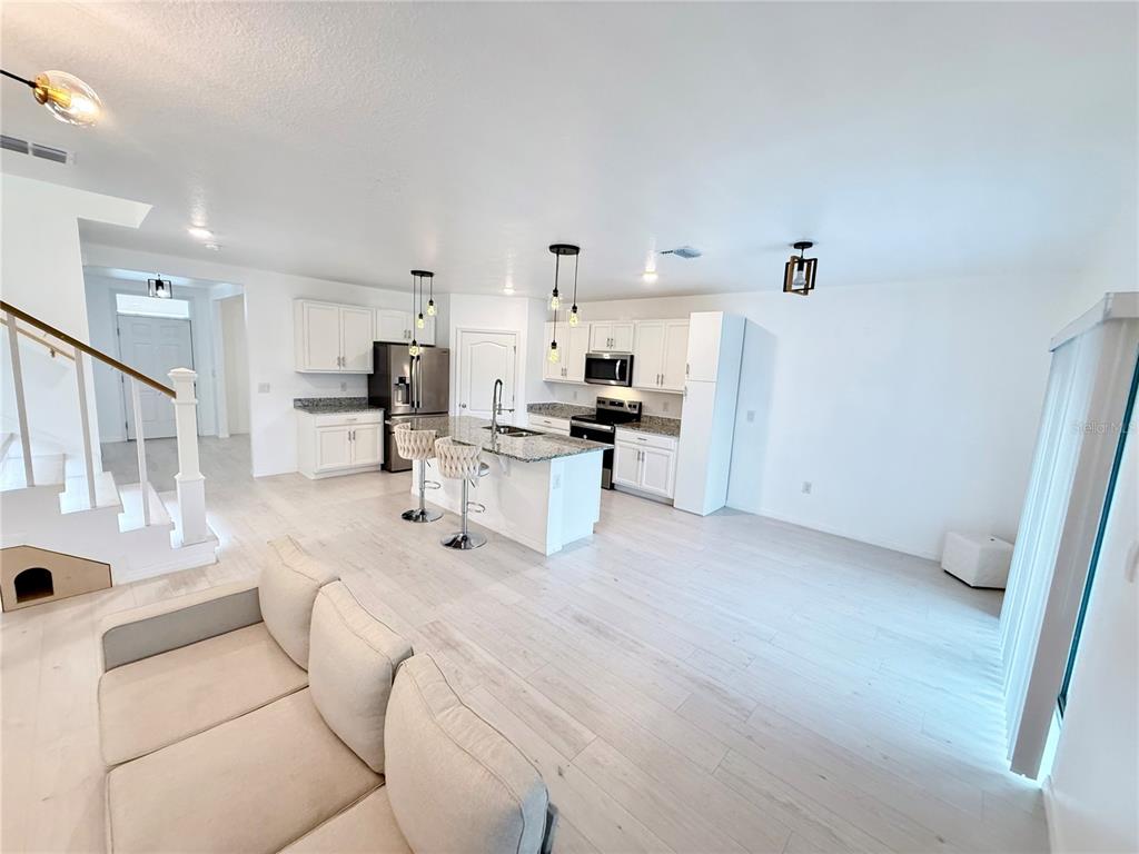 2731 House Finch Road Harmony, FL 34773 - Photo 20 of 95 a view of kitchen with furniture and wooden floor