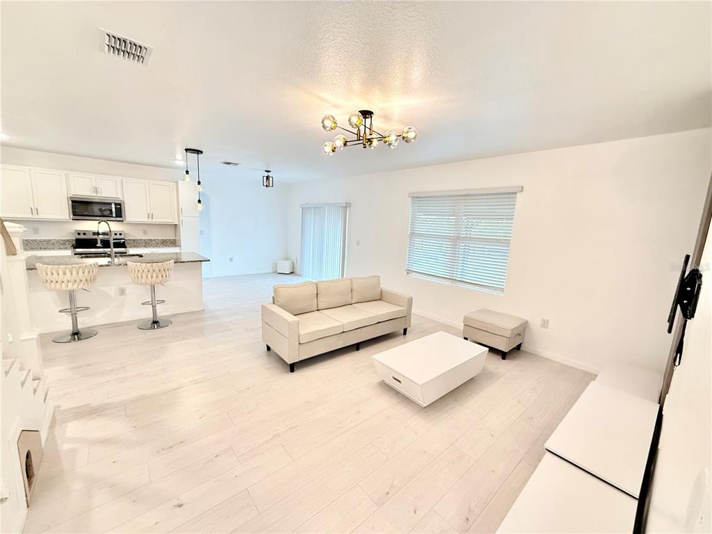 2731 House Finch Road Harmony, FL 34773 - Photo 22 of 95 a living room with furniture and a chandelier