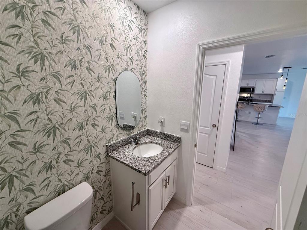 2731 House Finch Road Harmony, FL 34773 - Photo 30 of 95 a bathroom with a granite countertop sink and a mirror