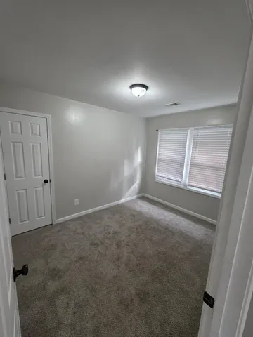 an empty room with windows and closet