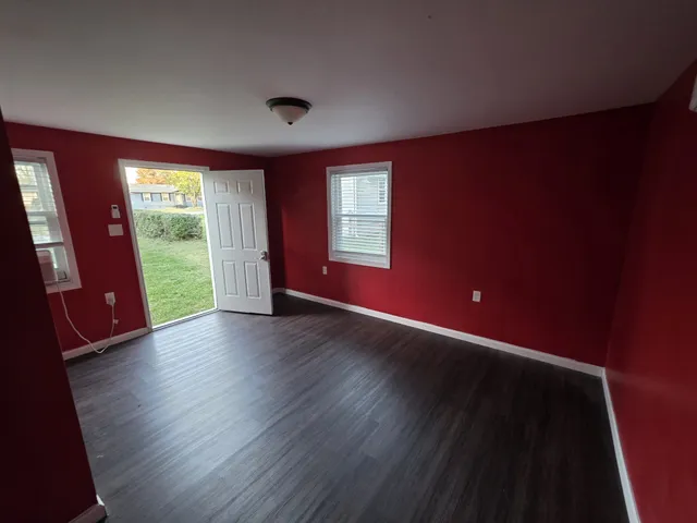 a view of an empty room with wooden floor