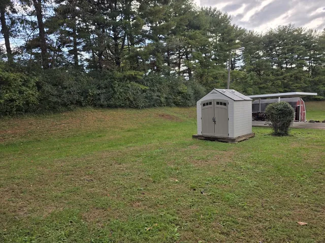 a view of house with yard and sitting area
