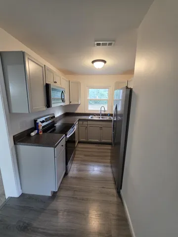 a kitchen with stainless steel appliances granite countertop a refrigerator a stove a sink and a microwave