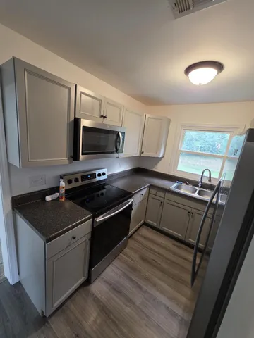 a kitchen with granite countertop a stove and a sink