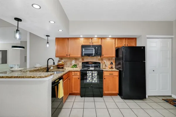 a kitchen with stainless steel appliances granite countertop a refrigerator a sink and a stove