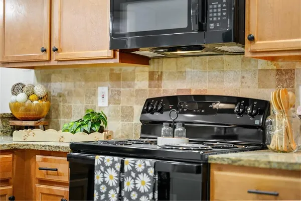 a kitchen with stainless steel appliances granite countertop a refrigerator and a stove