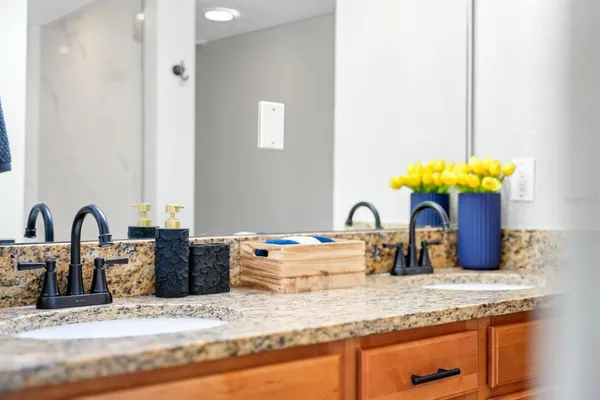 a bathroom with a granite countertop sink a toilet and a mirror