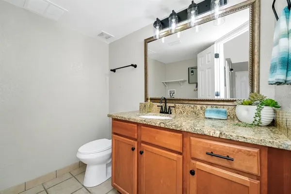 a bathroom with a granite countertop sink and a mirror