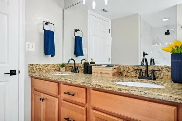 a bathroom with a granite countertop toilet sink and mirror